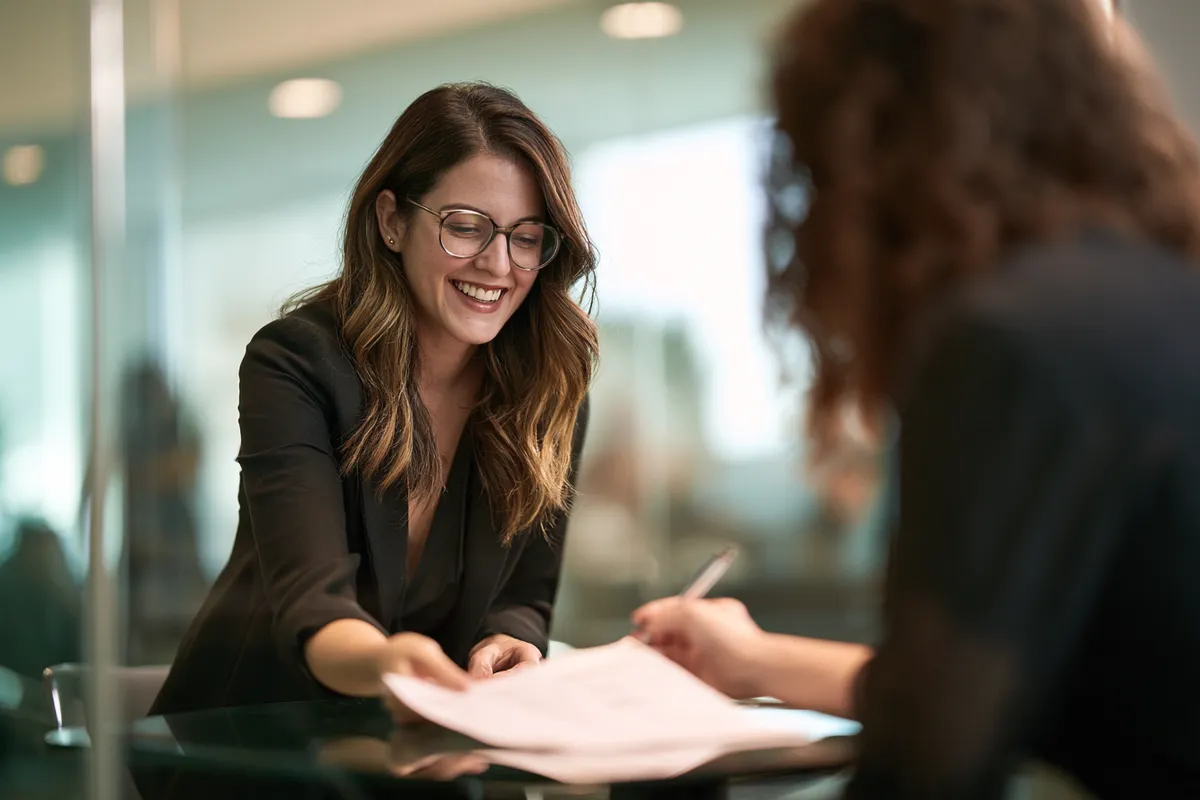 Hiring manager walking a candidate through a one-page checklist — eligibility is a short list, verified